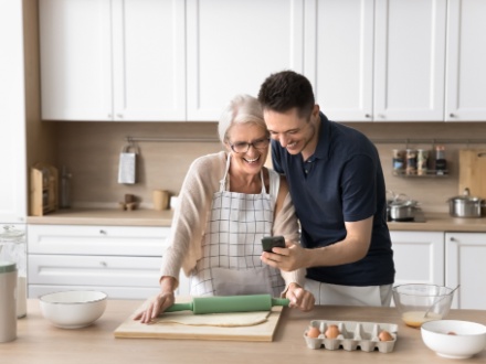 Grown up son spend time with mother in kitchen