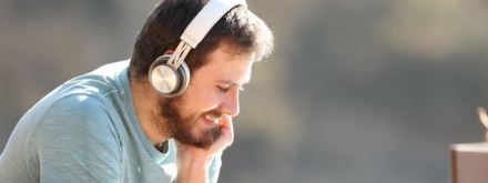 man with wireless headphones watching media content on tablet