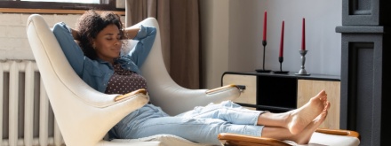 African woman at home relaxing in chair