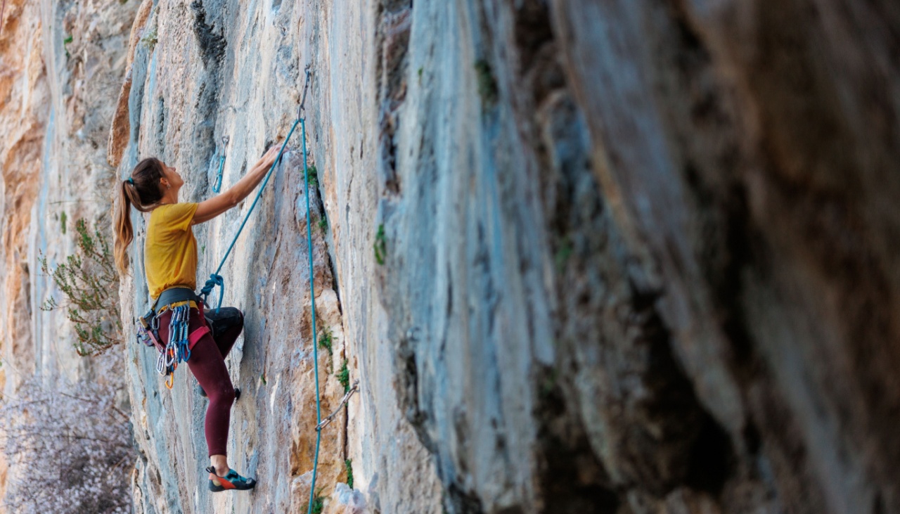 female rock climbing climbing side of rock