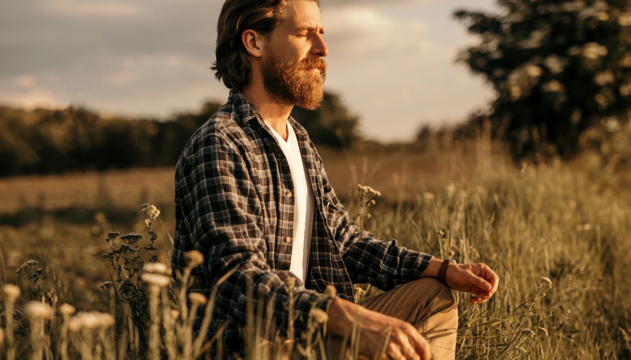man sitting in field meditating