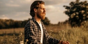 man sitting in field meditating