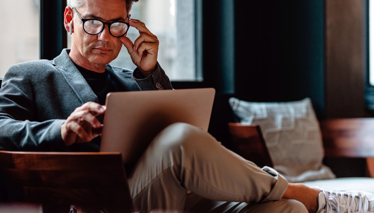 Man with glasses looking at laptop