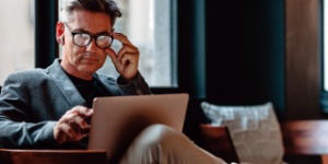 Man with glasses looking at laptop