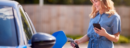 woman charging her blue ev car