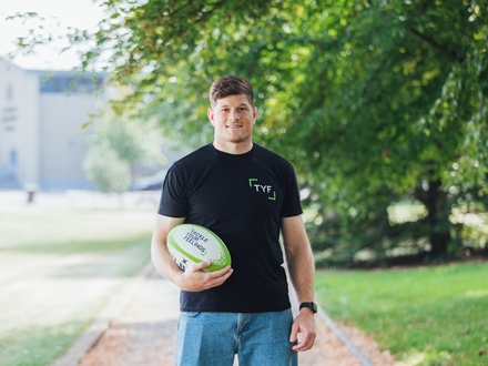 Rugby player Jack O’Donoghue holding a rugby ball with Tackle your feelings written on it