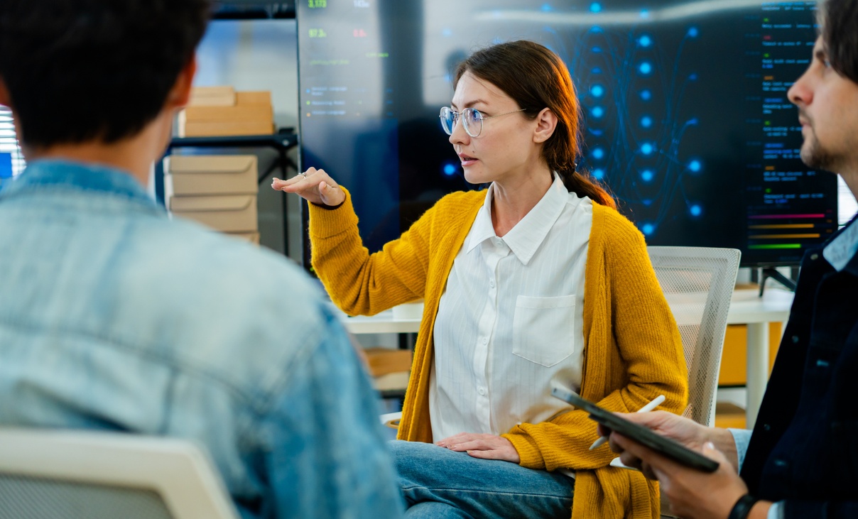 Asian woman in meeting with three colleagues