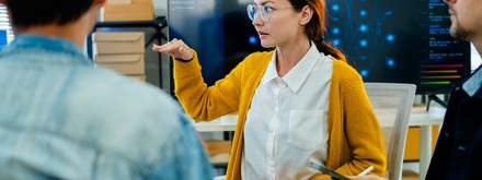 Asian woman in meeting with three colleagues