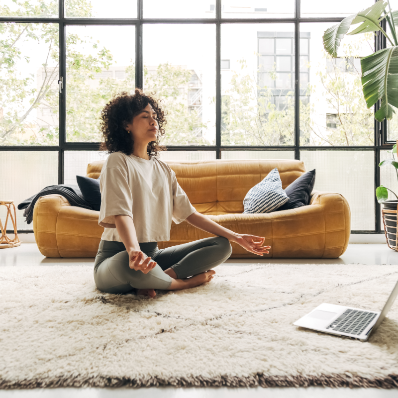 Person sitting on floor meditating