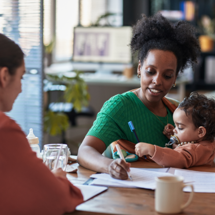 Mother holding baby in coffee shop with friend