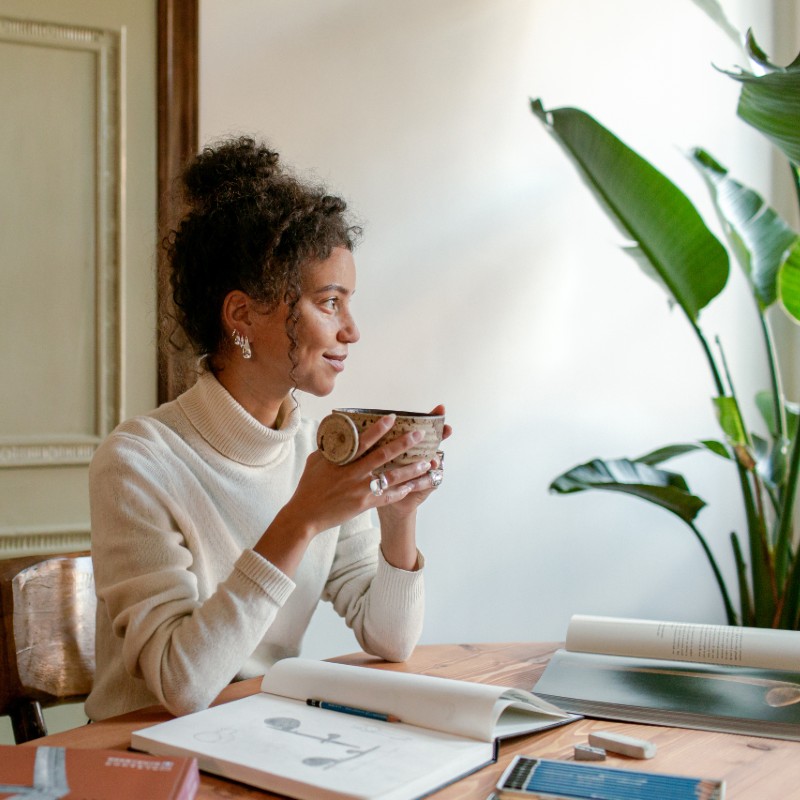 woman having coffee at desk at home