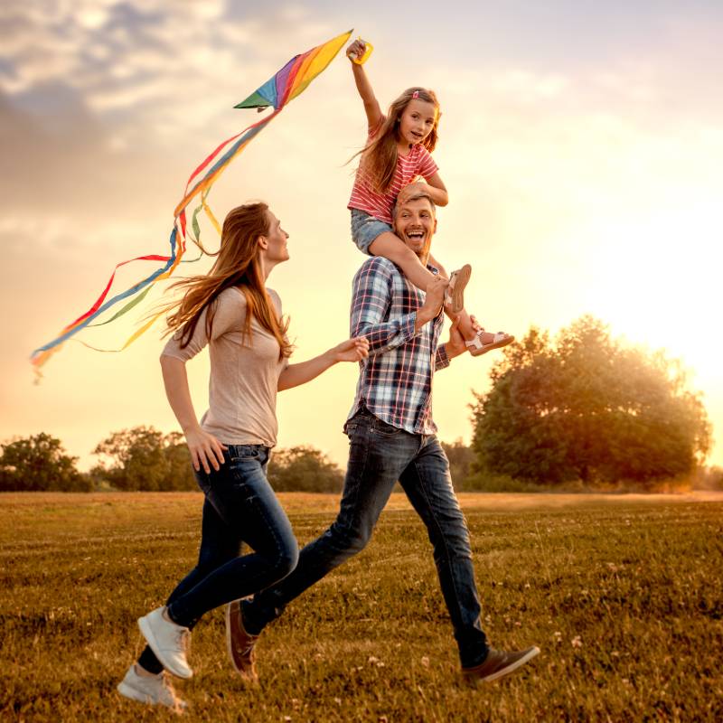 family running in park with kite