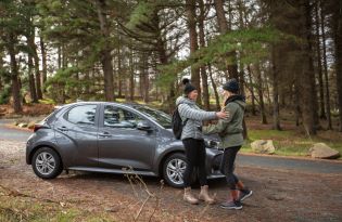 Two woman at car in forest