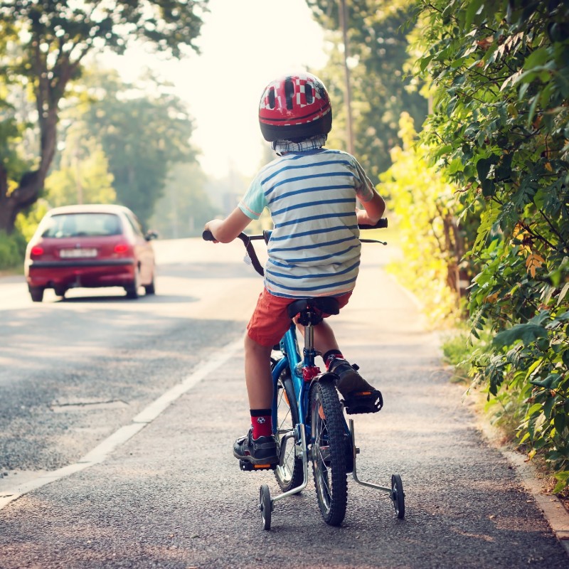 boy on bike with car on road