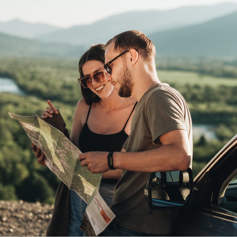 young couple reading map on roadtrip