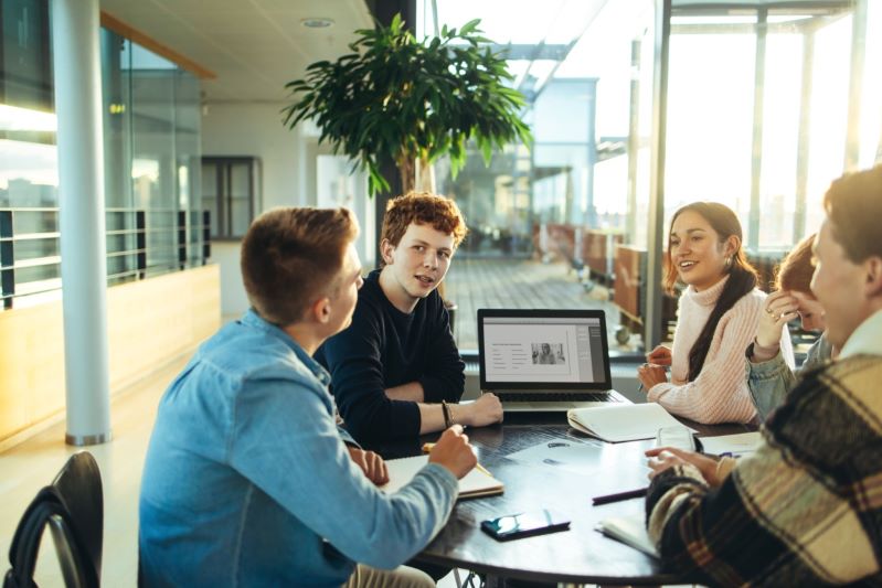 group of college students at table with laptop