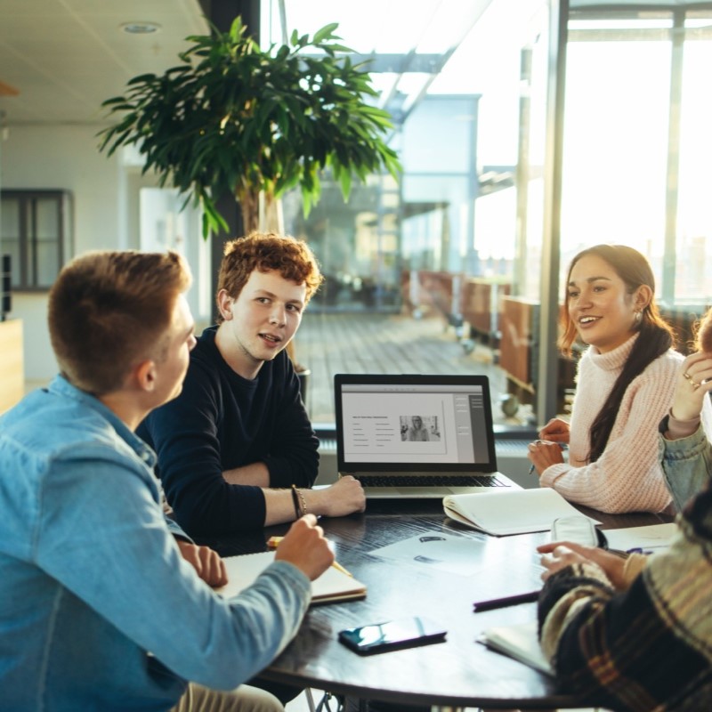 group of college students at table with laptop