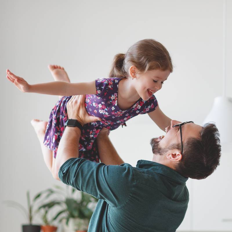 Father holding daughter in air