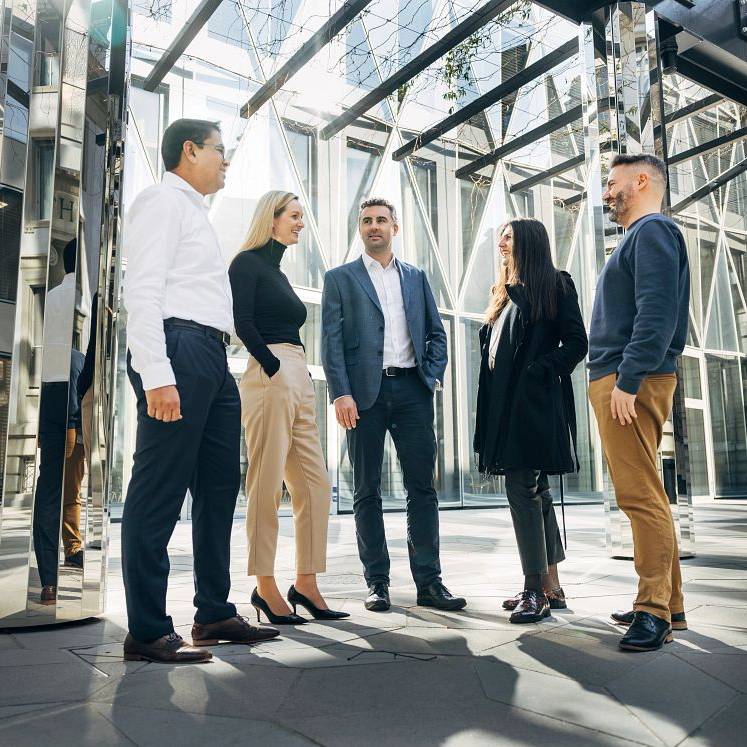 Group of business people standing together in modern office setting