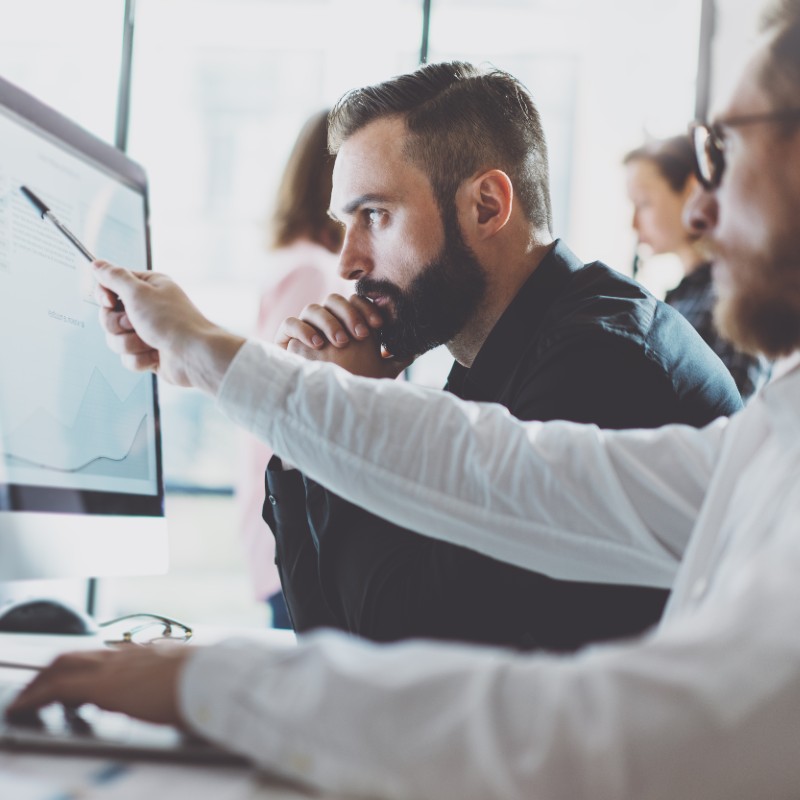 Two businessmen working on pc looking at investment market results