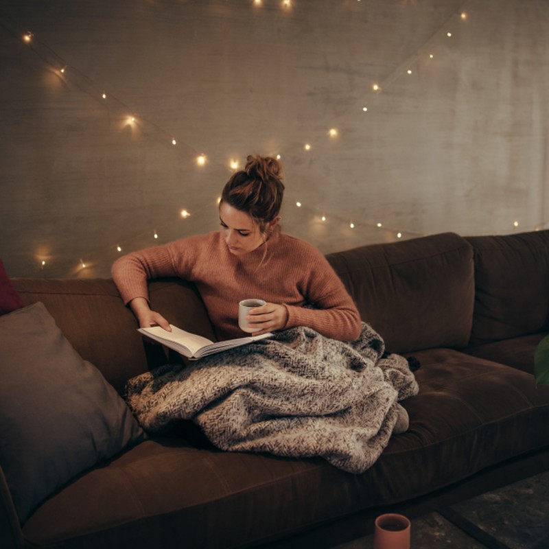 woman reading on couch at nighttime