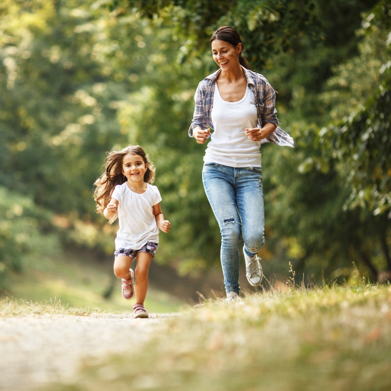 mother and daughter running in park
