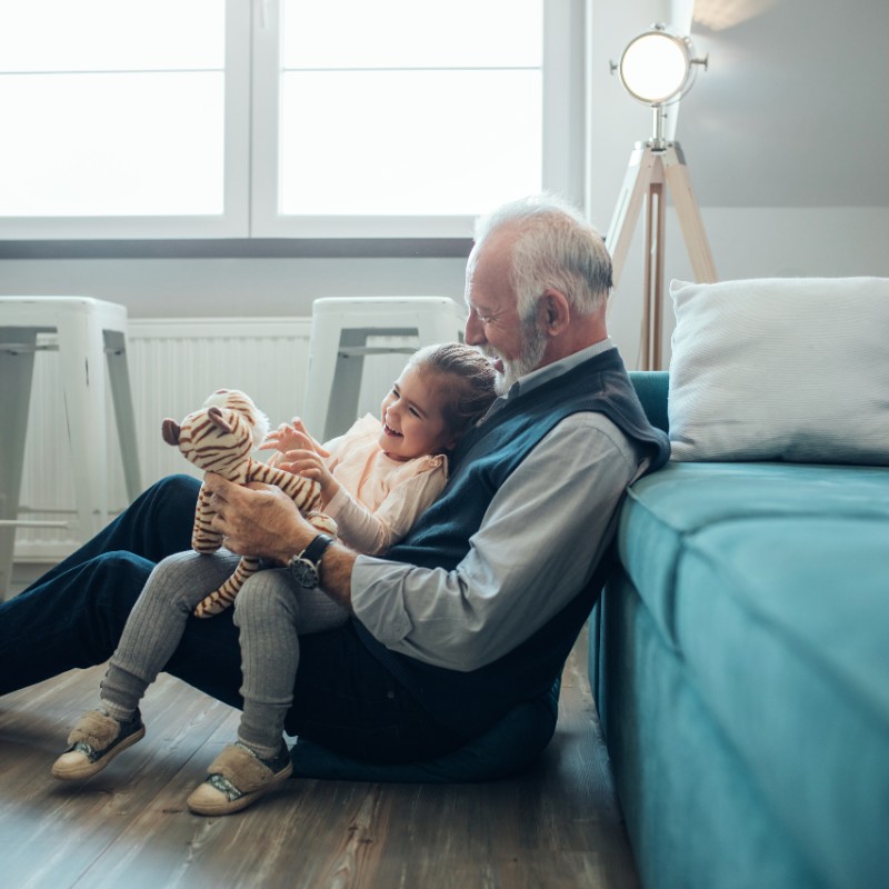grandfather and child playing with teddy