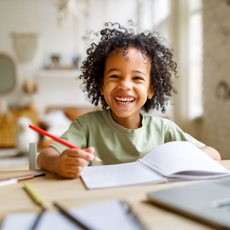 child writing in notebook