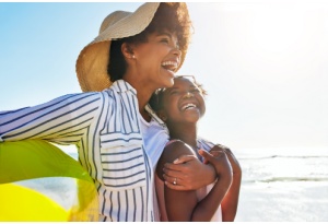Mother and daughter laughing on the beach